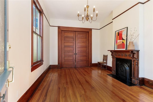 entrance foyer with an inviting chandelier and hardwood / wood-style flooring