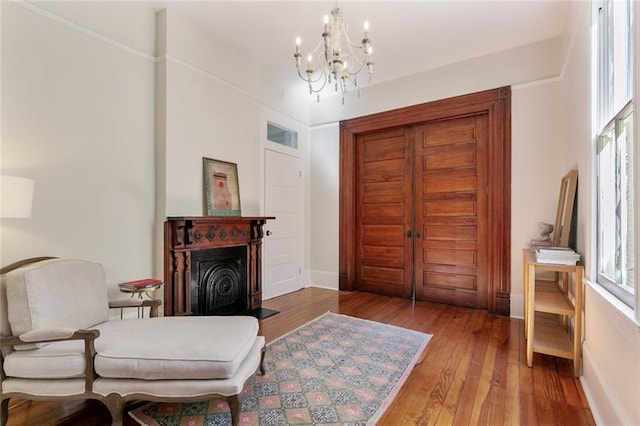 sitting room featuring wood-type flooring and a chandelier