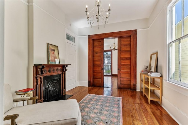 sitting room featuring a notable chandelier, hardwood / wood-style flooring, and a healthy amount of sunlight