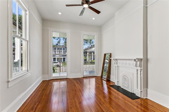 unfurnished living room featuring ceiling fan and hardwood / wood-style floors