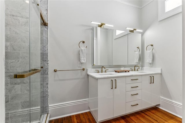 bathroom featuring wood-type flooring, a shower with door, and vanity