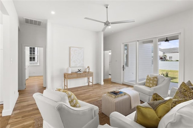 living room with ceiling fan and light hardwood / wood-style flooring