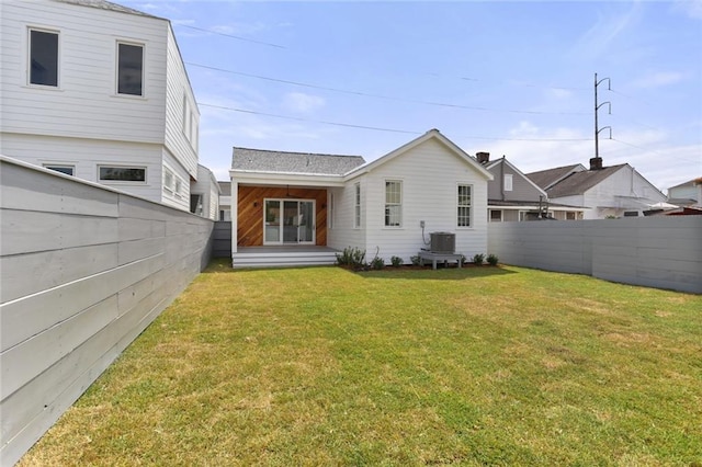 back of property featuring a lawn and central AC