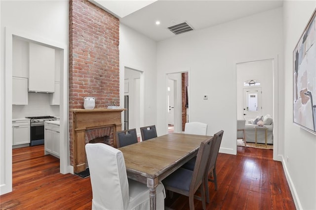 dining space featuring a fireplace and dark hardwood / wood-style flooring