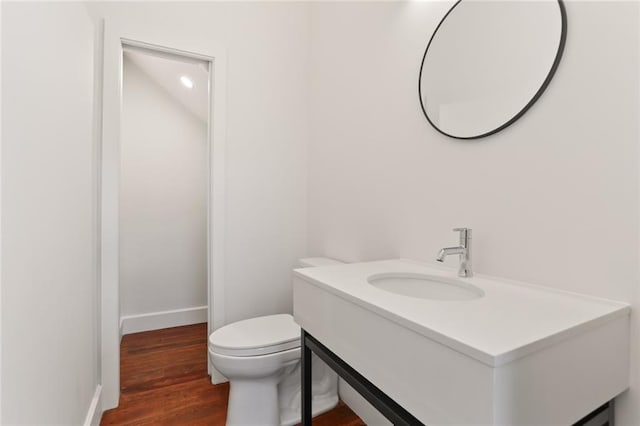 bathroom featuring vanity, hardwood / wood-style floors, and toilet