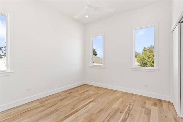 spare room with ceiling fan and light wood-type flooring