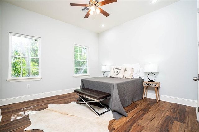 bedroom with multiple windows, dark hardwood / wood-style flooring, and ceiling fan