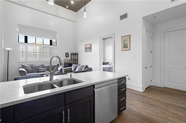 kitchen with hanging light fixtures, stainless steel dishwasher, dark hardwood / wood-style floors, a high ceiling, and sink