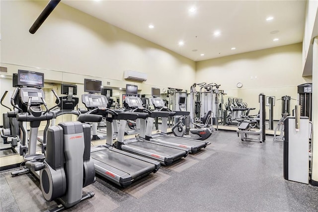 workout area with a high ceiling and a wall mounted air conditioner