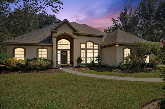 10 Catalpa Trce, Covington, LA 70433 - french country style house featuring stucco siding, a front lawn, and a shingled roof