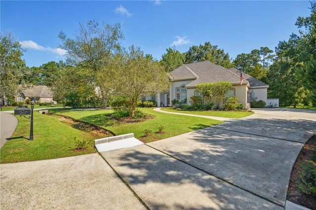 10 Catalpa Trce, Covington, LA 70433 - view of front of property featuring a front yard, concrete driveway, and stucco siding