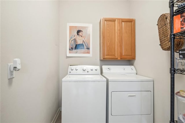 laundry area with cabinets and washing machine and clothes dryer