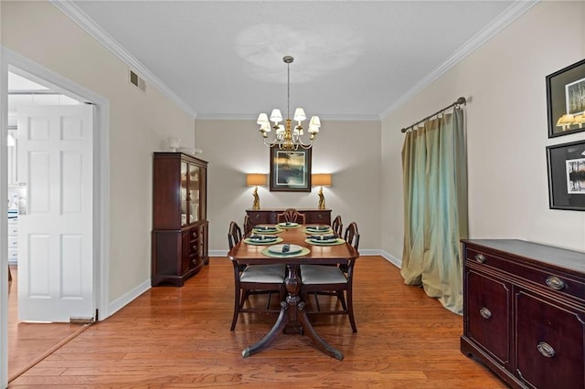 dining area with a notable chandelier, light hardwood / wood-style flooring, and crown molding