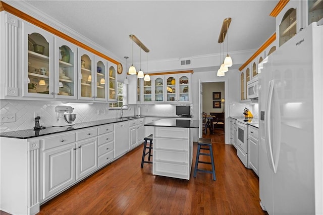 kitchen featuring hanging light fixtures, white cabinets, white appliances, crown molding, and a center island