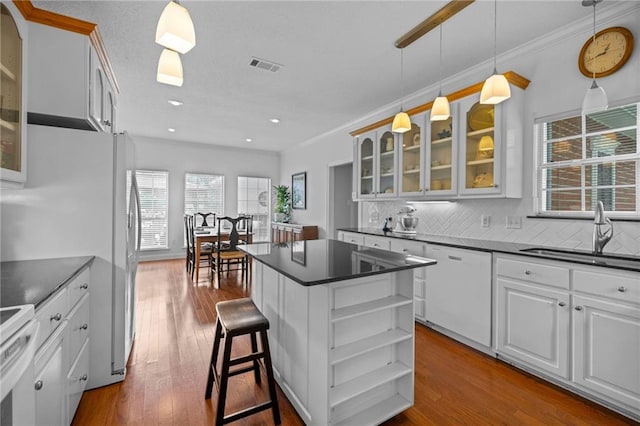 kitchen featuring sink, white appliances, light hardwood / wood-style flooring, white cabinetry, and a center island