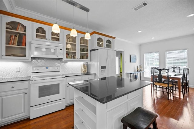 kitchen with a center island, dark wood-type flooring, white cabinets, white appliances, and crown molding