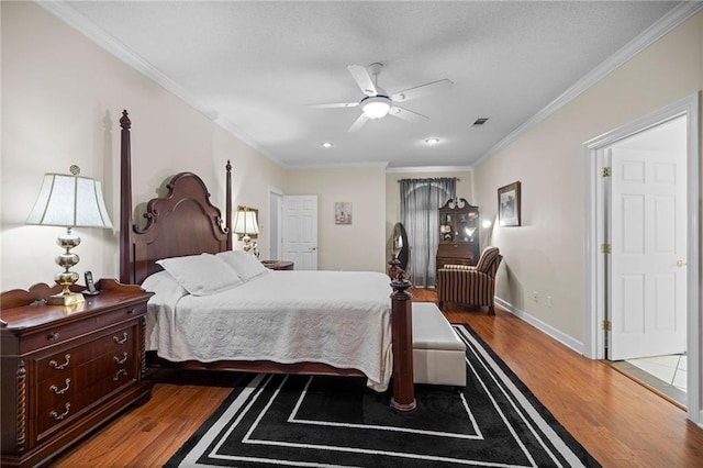 bedroom featuring ceiling fan, hardwood / wood-style flooring, and crown molding