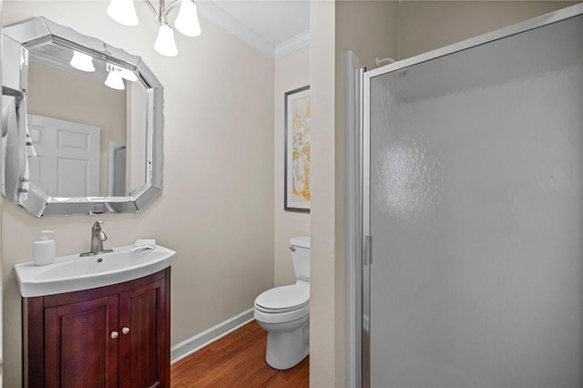 bathroom featuring vanity, toilet, ornamental molding, walk in shower, and hardwood / wood-style floors