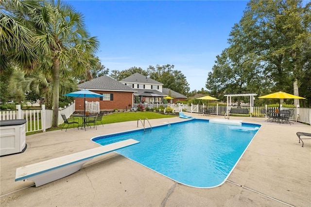 view of pool featuring a patio and a diving board