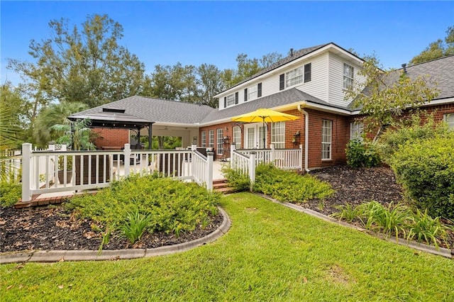 back of house featuring a lawn and a wooden deck