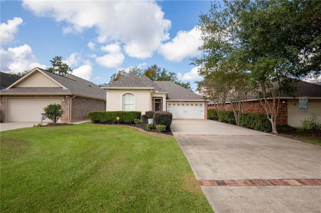 18 Pin Oak Ln, Hammond, LA 70401 - view of front of home featuring concrete driveway, a garage, a front yard, brick siding, and stucco siding