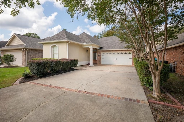 18 Pin Oak Ln, Hammond, LA 70401 - view of front of property featuring an attached garage, concrete driveway, stucco siding, a shingled roof, and brick siding