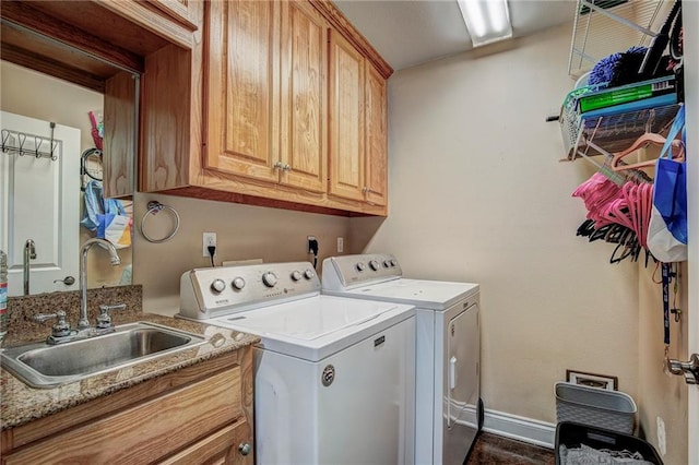 washroom with sink, washing machine and clothes dryer, and cabinets