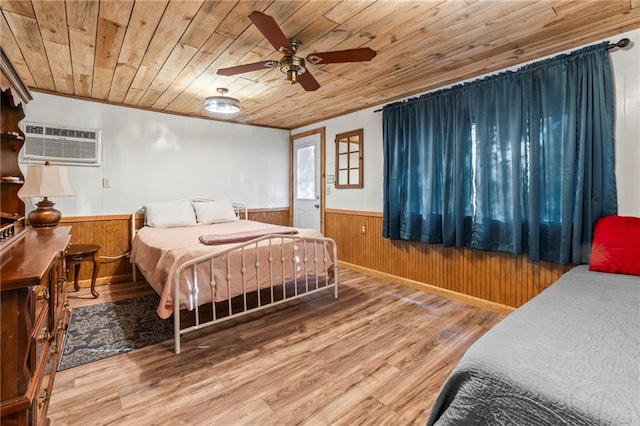 bedroom featuring wood ceiling, a wall unit AC, hardwood / wood-style flooring, and ceiling fan