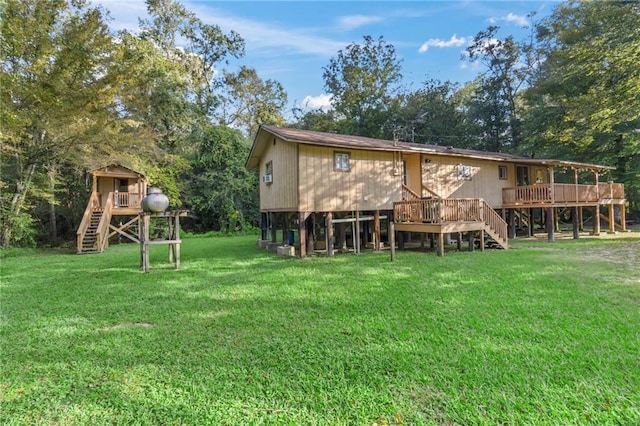 rear view of house with a yard and a wooden deck