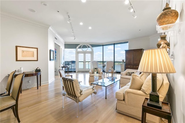 living room featuring a wall of windows, light hardwood / wood-style floors, track lighting, french doors, and ornamental molding