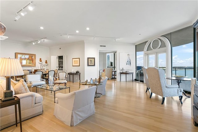 living room featuring ornamental molding, a water view, and light hardwood / wood-style floors