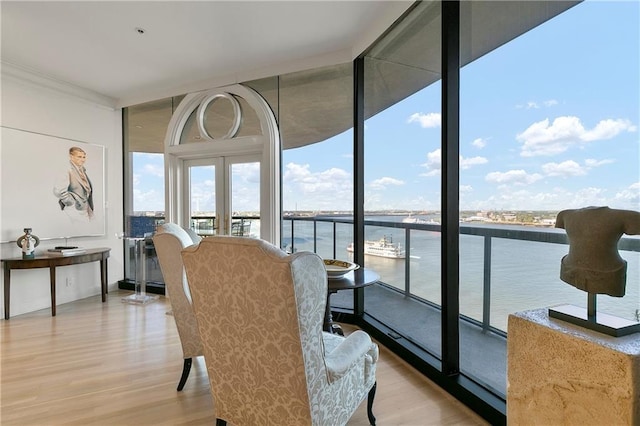 sunroom / solarium with french doors and a water view