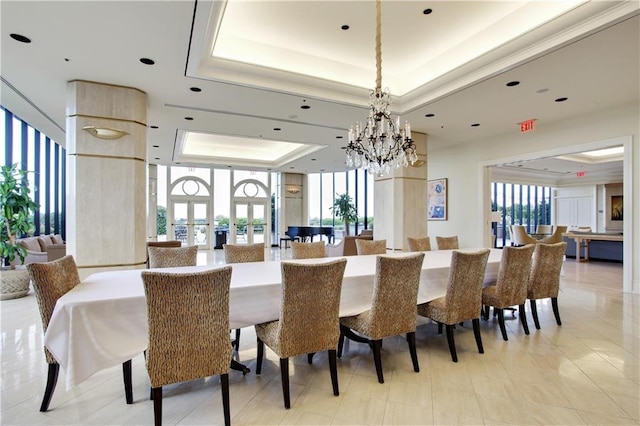 dining area with light tile patterned floors, a raised ceiling, and a chandelier