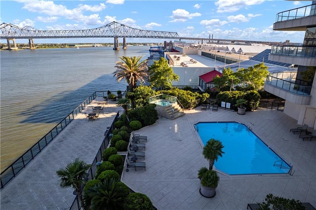 view of pool featuring a patio, a water view, and a jacuzzi