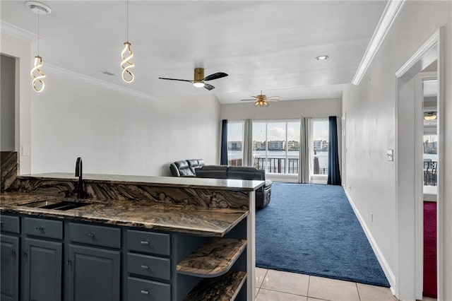 kitchen featuring crown molding, sink, light tile patterned floors, and pendant lighting