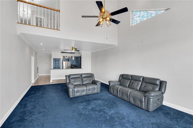 living room with crown molding, a towering ceiling, ceiling fan, and carpet flooring