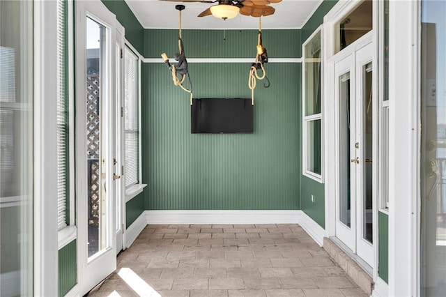 unfurnished sunroom featuring french doors and ceiling fan