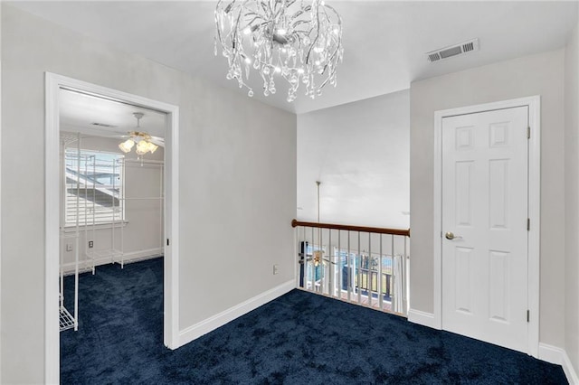 unfurnished room with ceiling fan and dark carpet