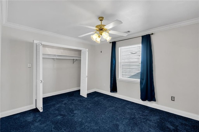 unfurnished bedroom featuring crown molding, ceiling fan, a closet, and dark colored carpet