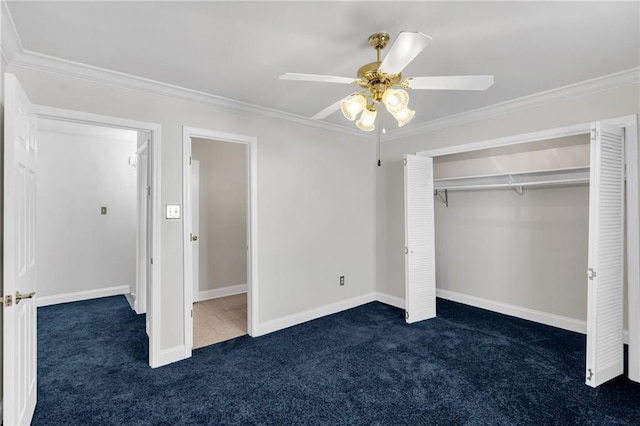 unfurnished bedroom featuring crown molding, a closet, ceiling fan, and dark colored carpet