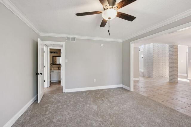 carpeted spare room with crown molding and ceiling fan