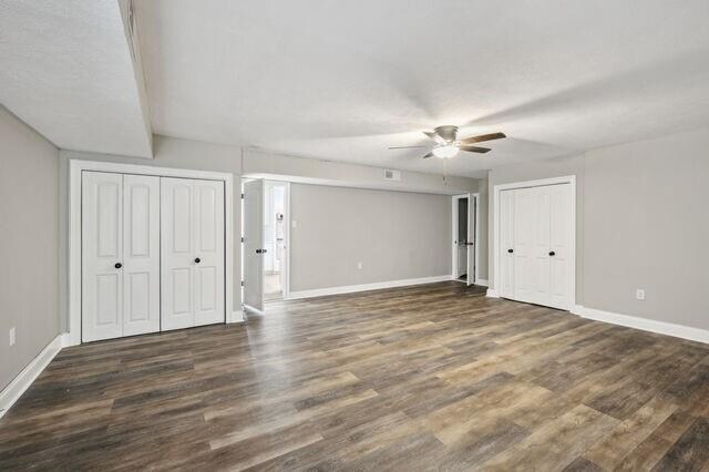 interior space with ceiling fan and dark hardwood / wood-style flooring