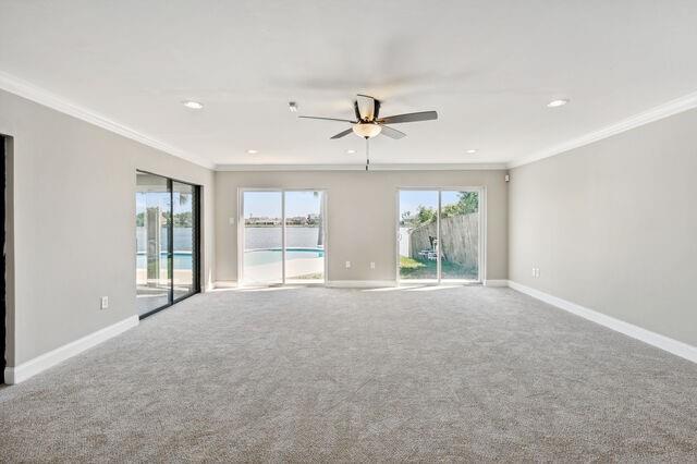 spare room featuring ceiling fan, crown molding, and carpet flooring