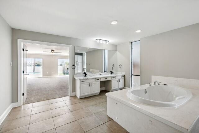 bathroom featuring ceiling fan, vanity, tile patterned flooring, and a tub