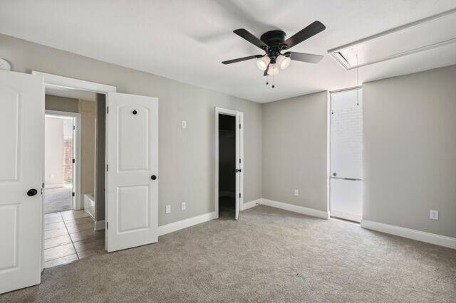 unfurnished bedroom with ceiling fan and light colored carpet