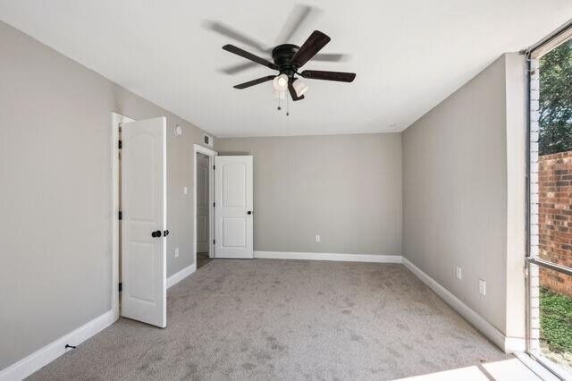 spare room featuring ceiling fan and light carpet