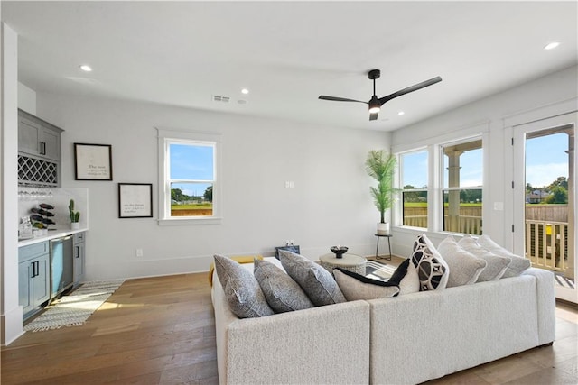 living room with wood-type flooring and ceiling fan