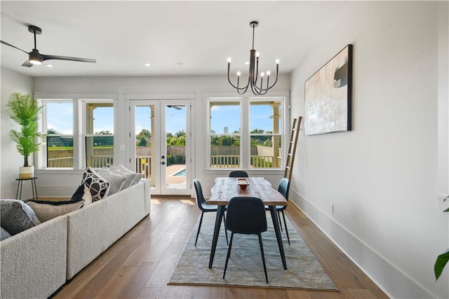 dining space featuring ceiling fan with notable chandelier, hardwood / wood-style floors, and french doors