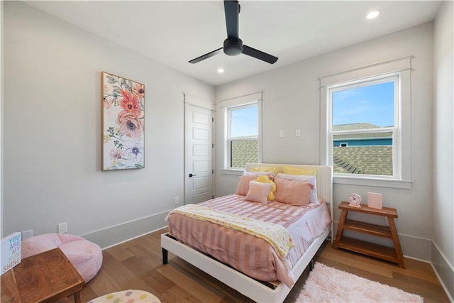 bedroom featuring wood-type flooring, multiple windows, and ceiling fan