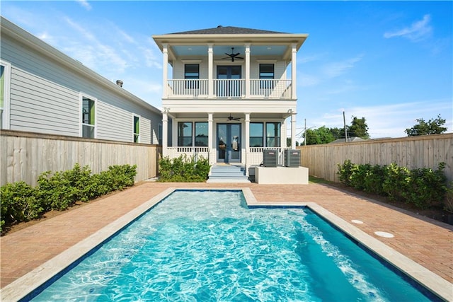 back of house featuring a balcony, a patio, a fenced in pool, and ceiling fan